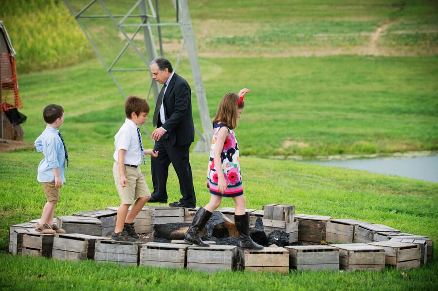 a grandfather and his grandchildren walk around a fire pit on top of apple crates outdoor wedding in pittsburgh