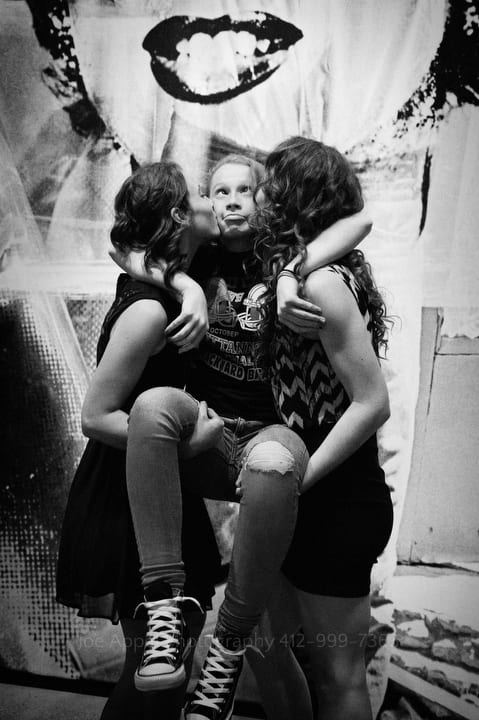 two girls kiss their sister on the cheeks as they pick her up off of the ground andy warhol museum wedding