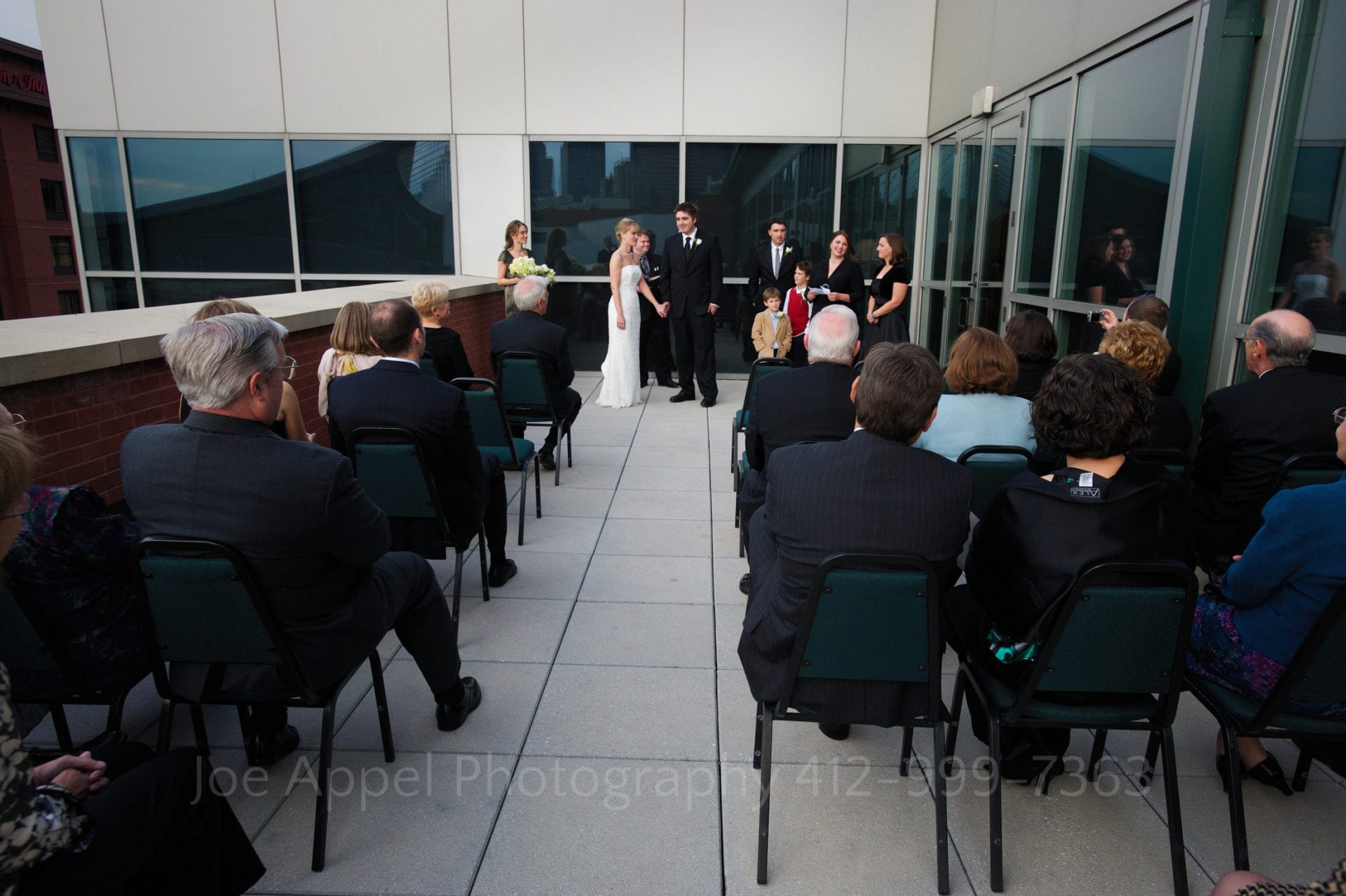 Overall view of a wedding ceremony on the patio outside of the Mueller Center at the Heinz history center.