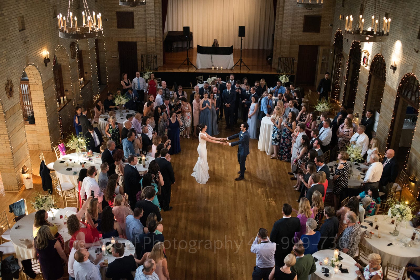 As seen from high above, a bride and groom dance while their guests surround them during their St Francis Hall Washington DC wedding.