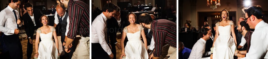 bride is picked up in a chair before the hora dance at a wedding