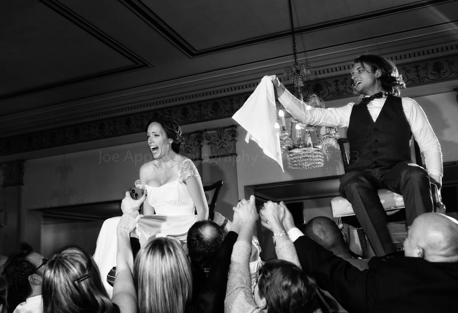 bride and groom are held aloft in chairs during a hora dance at a wedding twentieth century club wedding pittsburgh