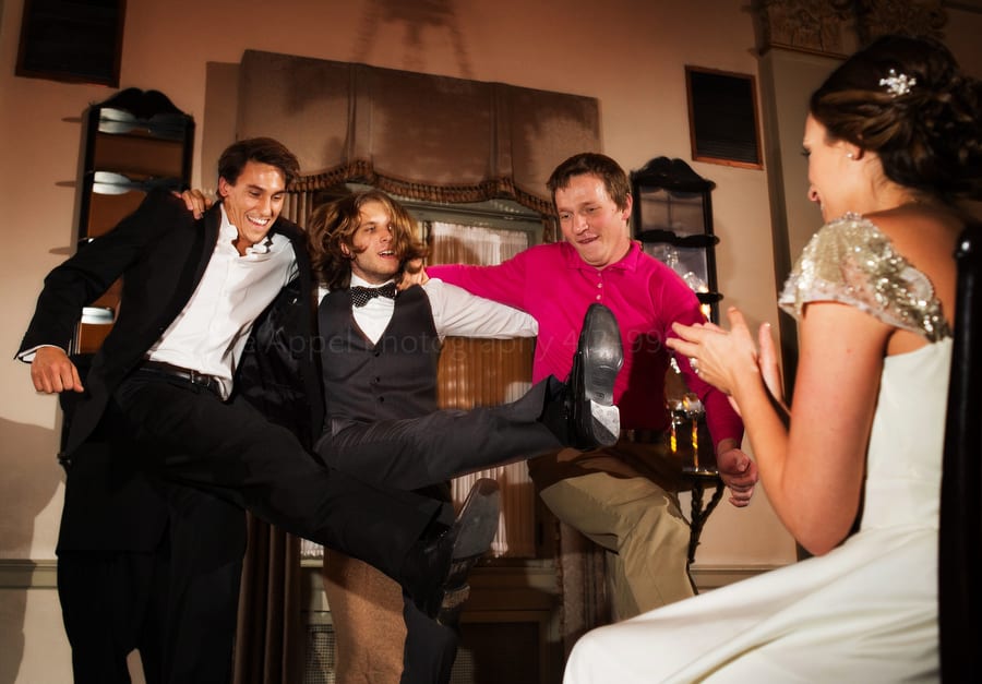 groom dances with his friends at a wedding reception