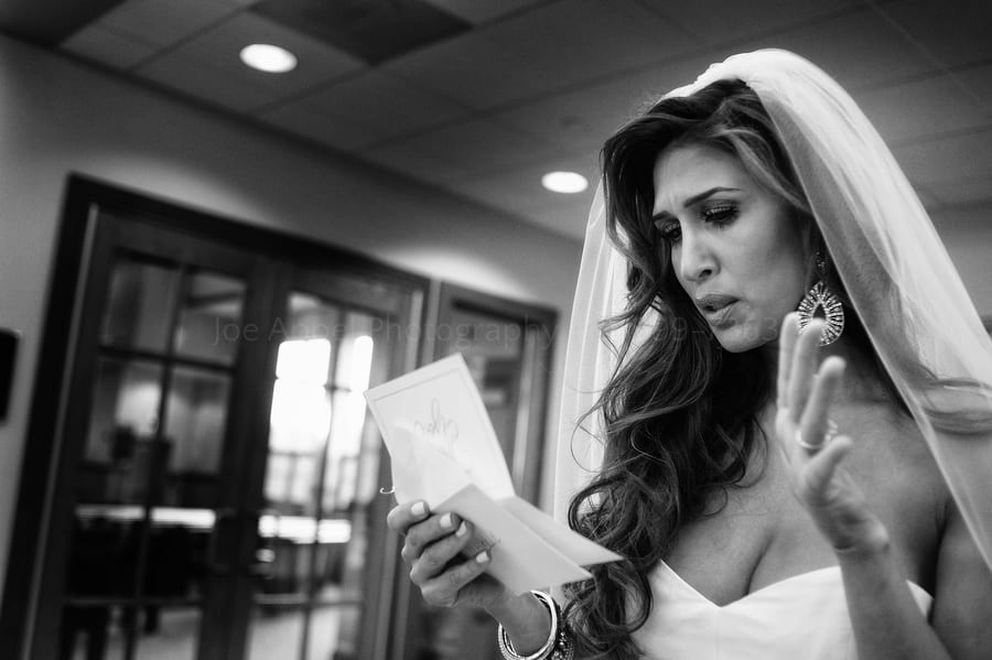 a bride cries as she reads a letter her groom wrote her