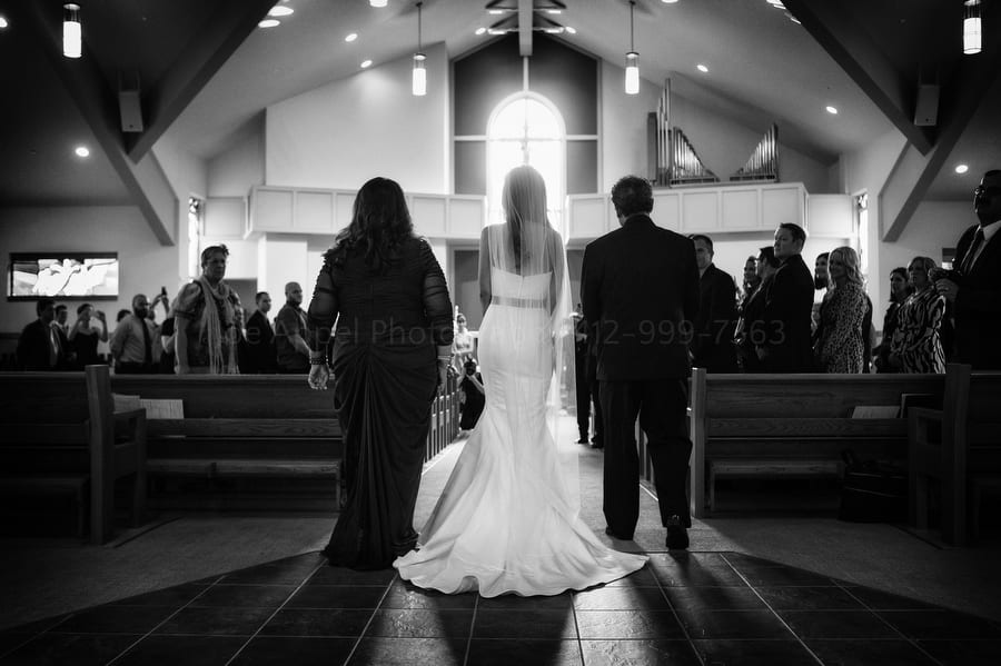 a bride walks with her parents down the aisle at her wedding near Pittsburgh