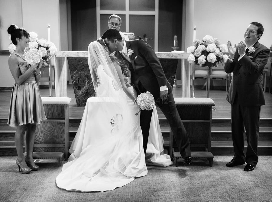 a bride and groom kiss at the end of their wedding ceremony near Pittsburgh as the best man and maid of honor applaud.