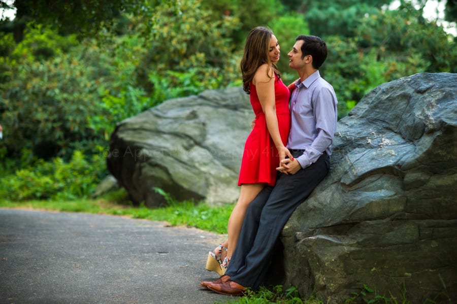 a beautiful woman in a red dress with her boyfriend on a path in central park