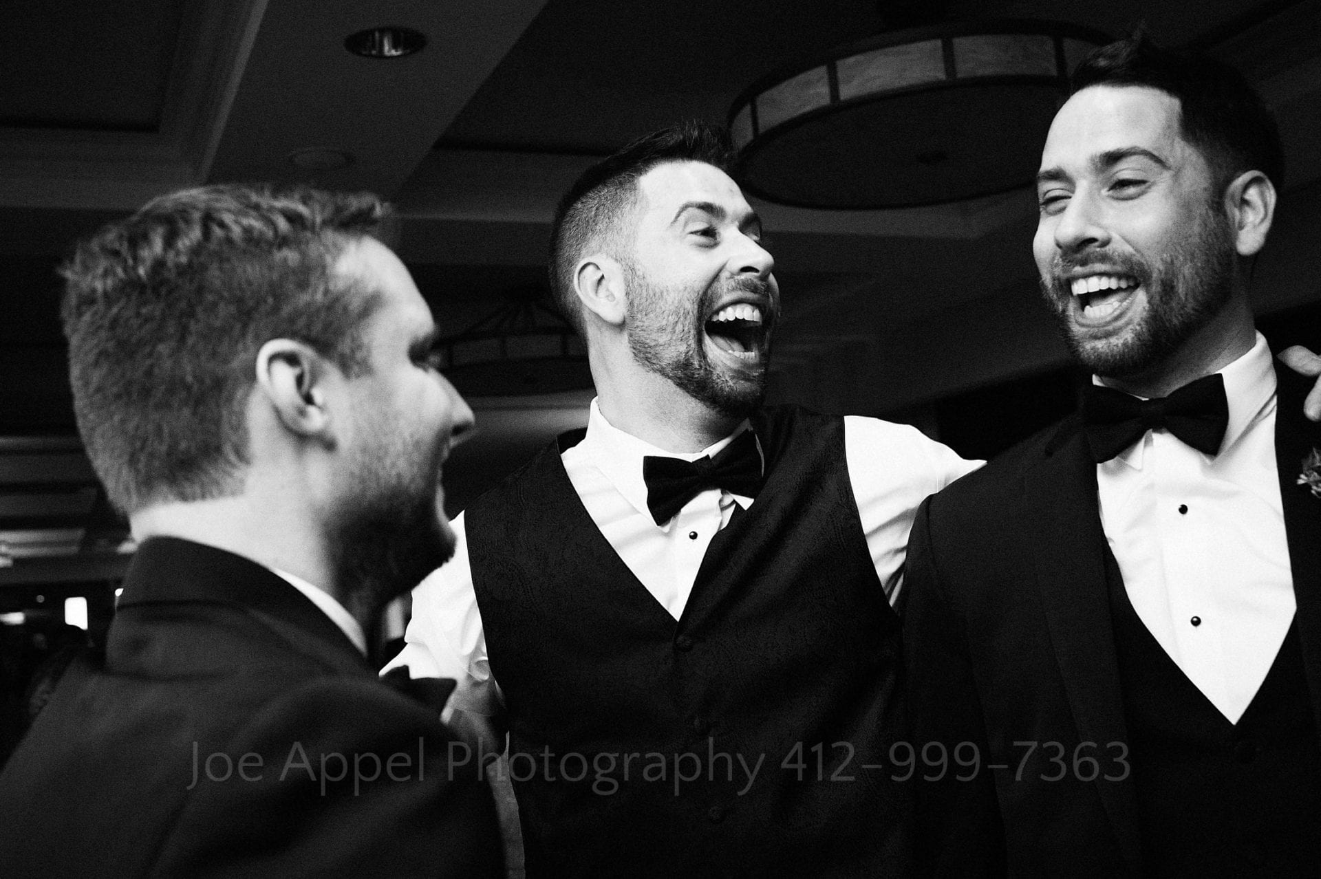 Three tuxedoed brothers, the middle one the groom, laugh and dance together at a Renaissance Pittsburgh Hotel Wedding.