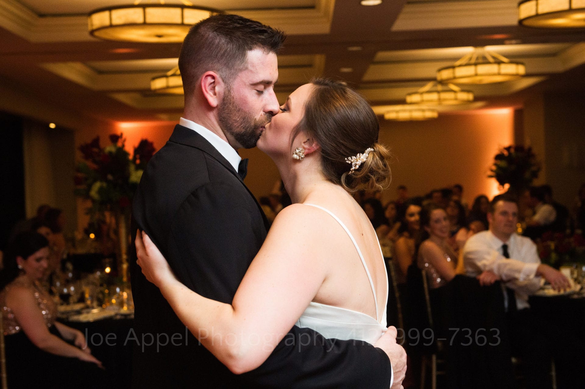 A bride and groom share a kiss on the dance floor at the Renaissance Pittsburgh Hotel during their wedding reception.