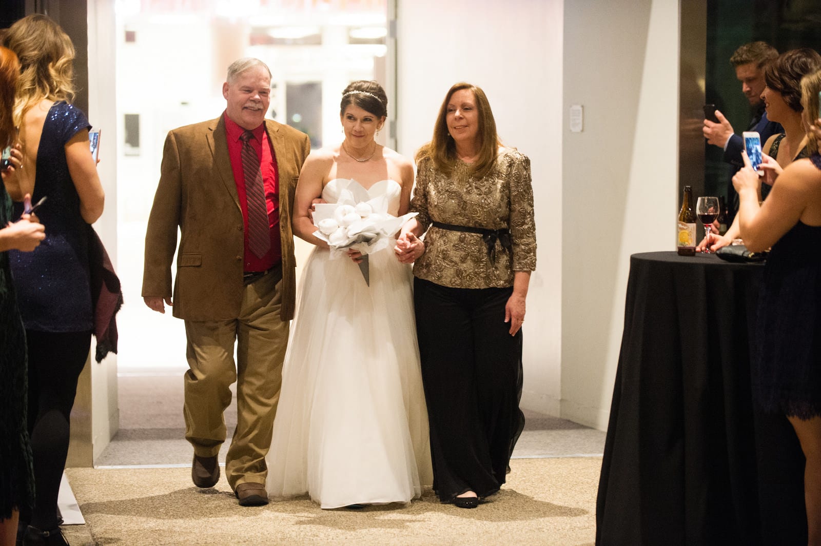 A bride walks into her Children's Museum Pittsburgh Wedding accompanied by her parents.