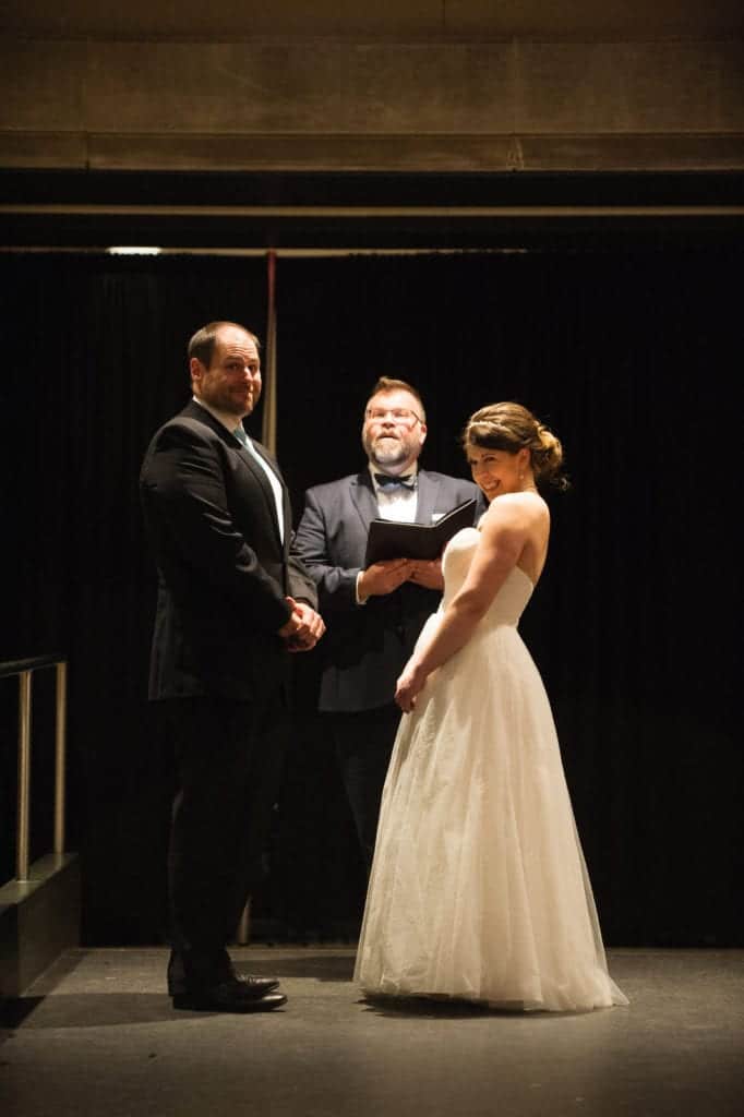 A bride and groom make faces as their officiant talks during their Children's Museum Pittsburgh Wedding.