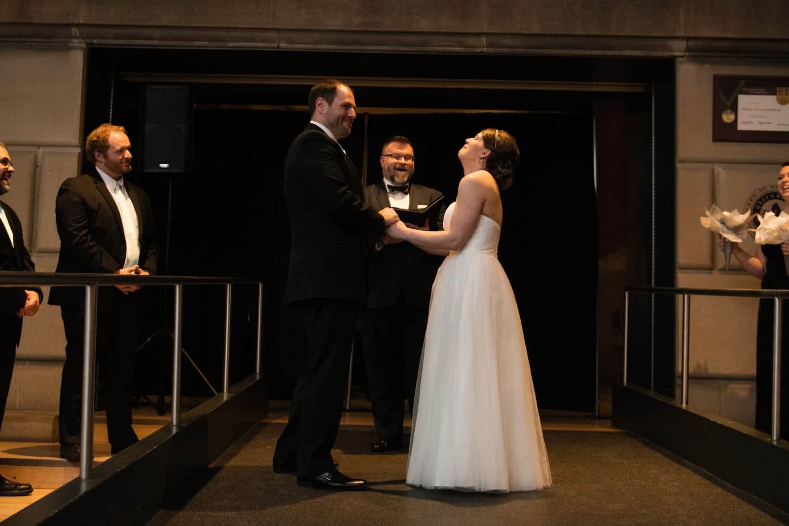 A bride and groom laugh while exchanging rings during their Children's Museum Pittsburgh Wedding.