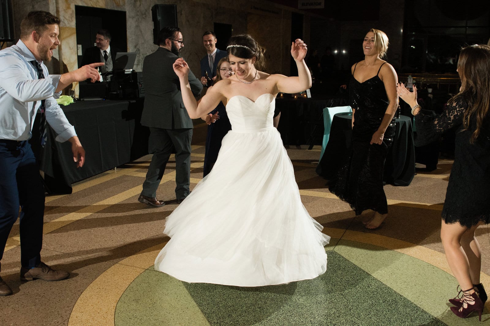 A bride dances in the middle of guests gathered around her during her Children's Museum Pittsburgh Wedding.