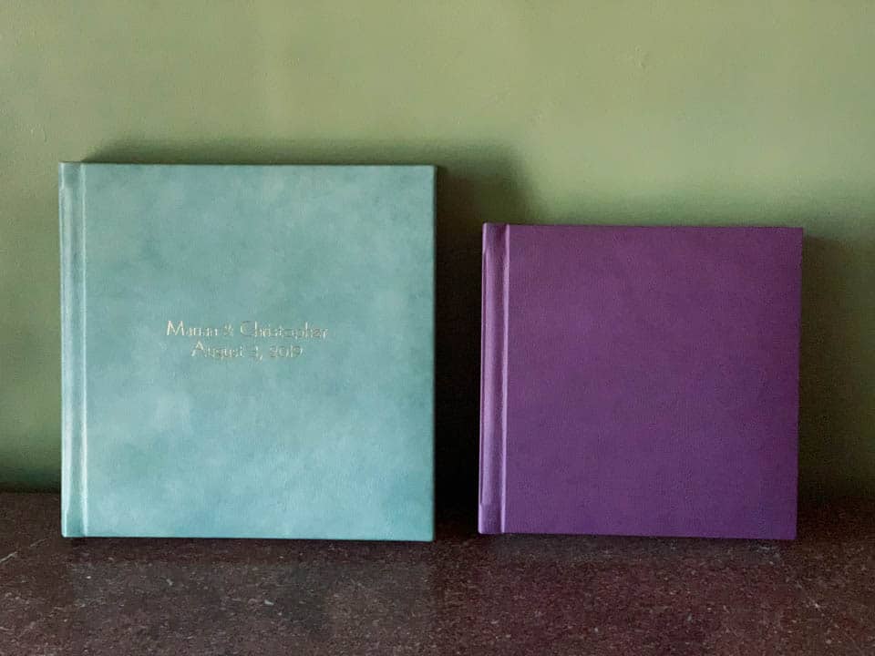 Two beautiful wedding albums: one a 12x12 and one a 10x10. The covers are bold colors purple and sea blue/green.