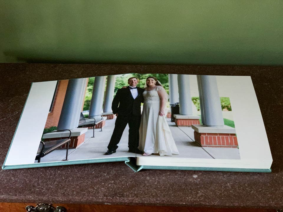 The opening spread of a 12x12 wedding album features a portrait of the bride and groom.