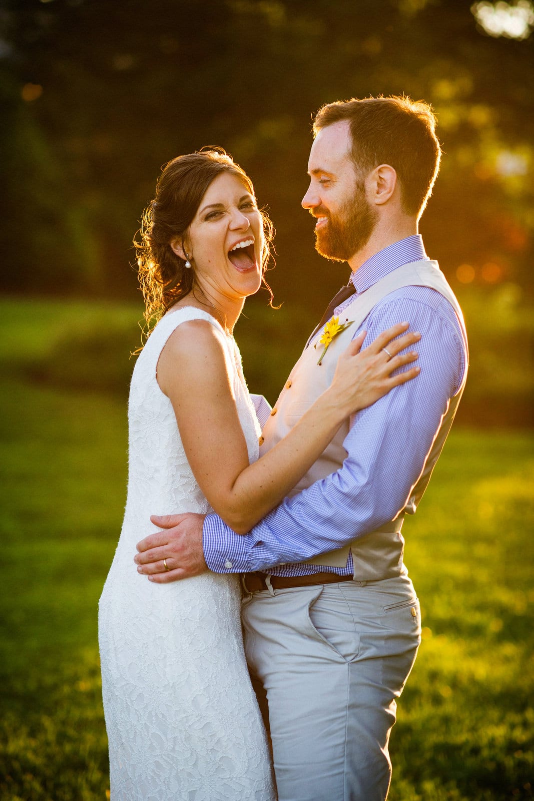 A bride laughs as she and her groom stand in the late afternoon sun after their wedding at Armstrong Farms.