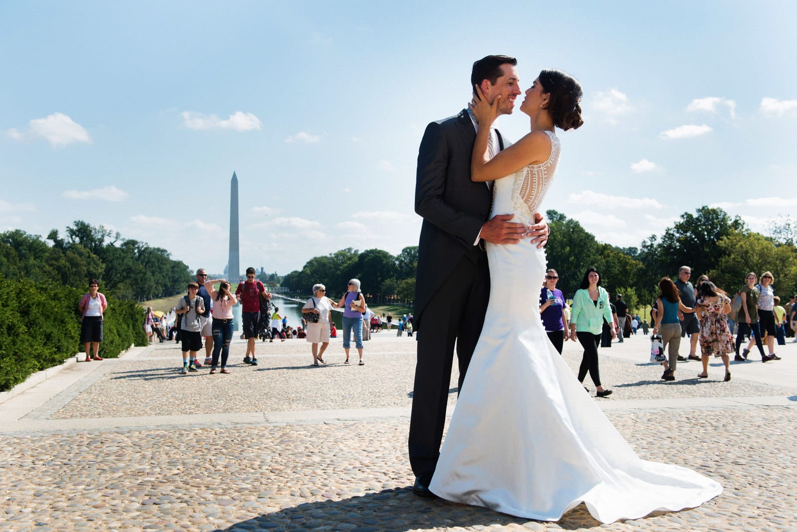 A bride and groom stand on the steps in front of the Lincoln memorial in Washington DC.