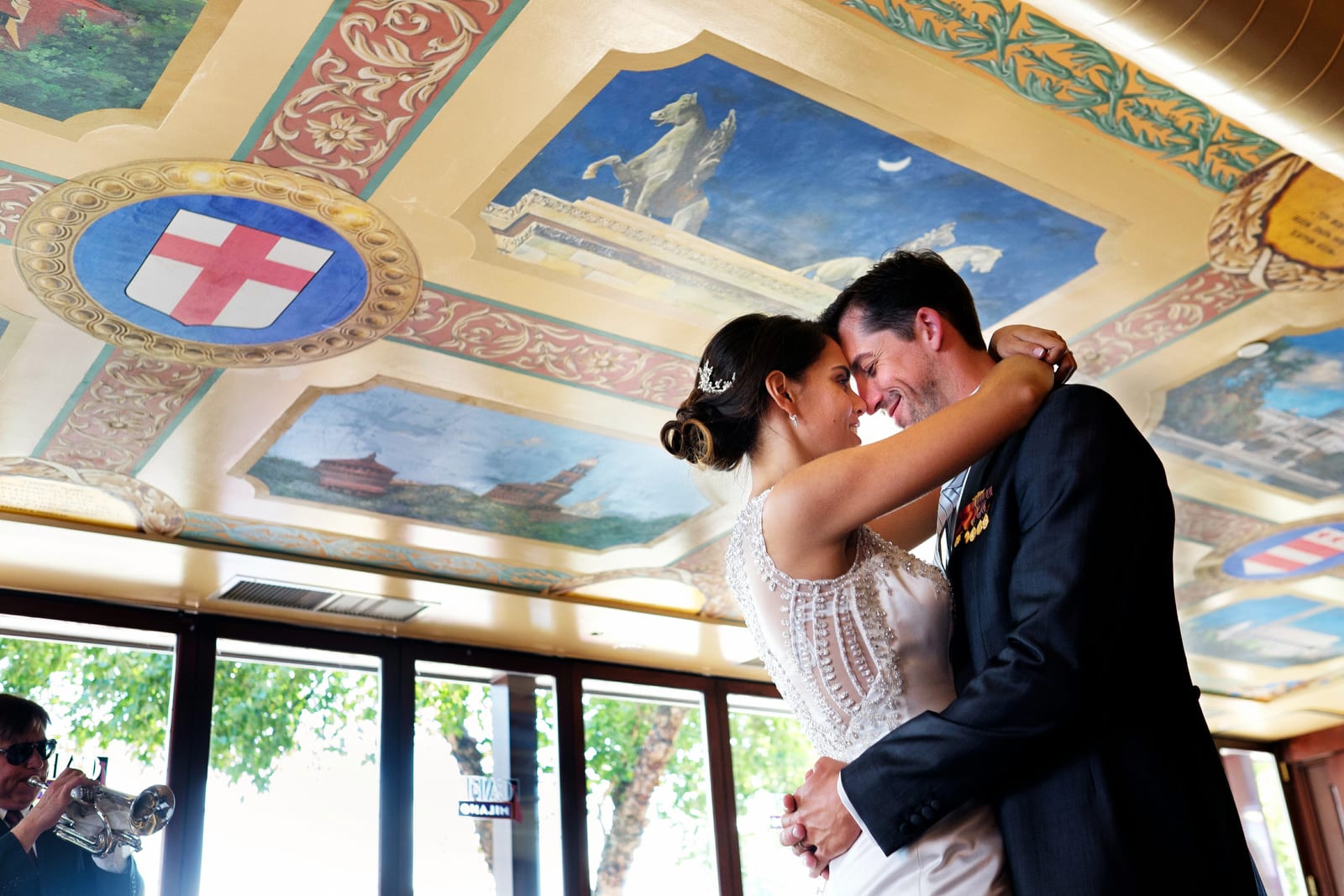A bride and groom dance forehead to forehead beneath the painted ceiling during their wedding at Cafe Milano in Washington, DC.