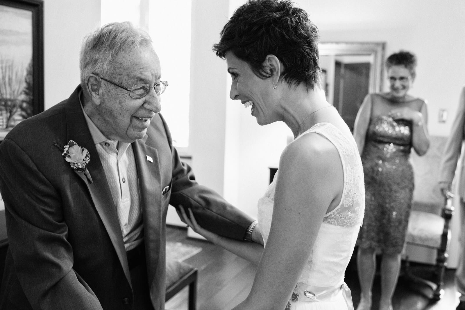 A bride smiles at her grandfather while her mother watches before her wedding at the Succop Conservancy.