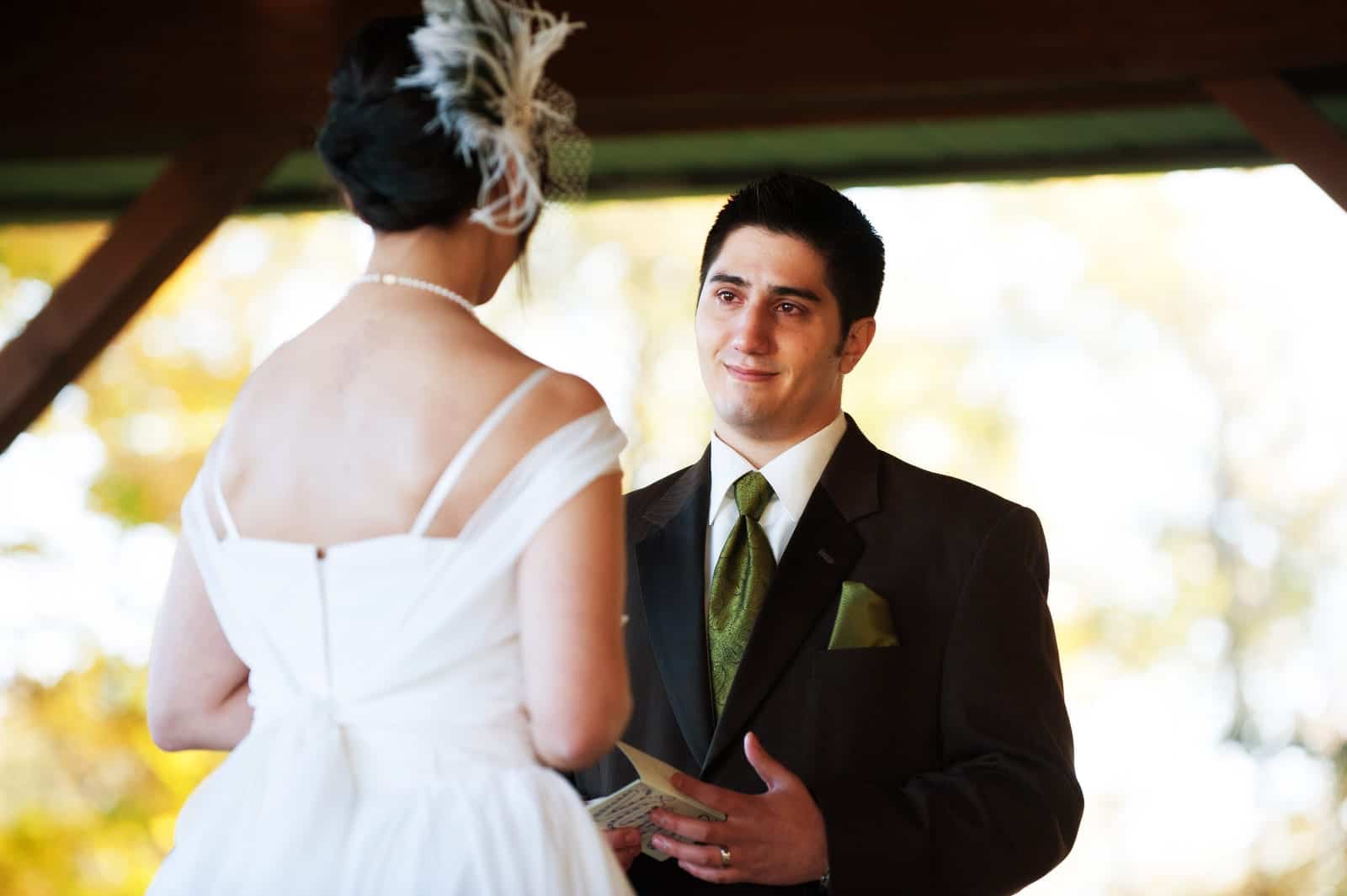 A groom cries as he exchanges vows with his bride in a pavilion during their wedding at the SNPJ.