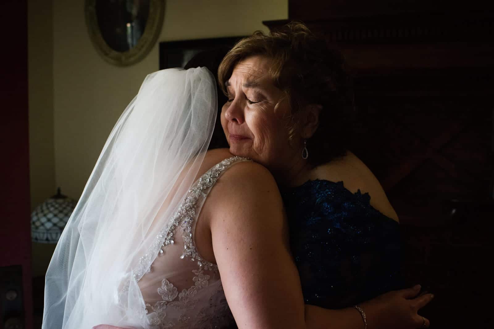 Mother of the bride cries as she hugs the bride before a Grand Concourse wedding.