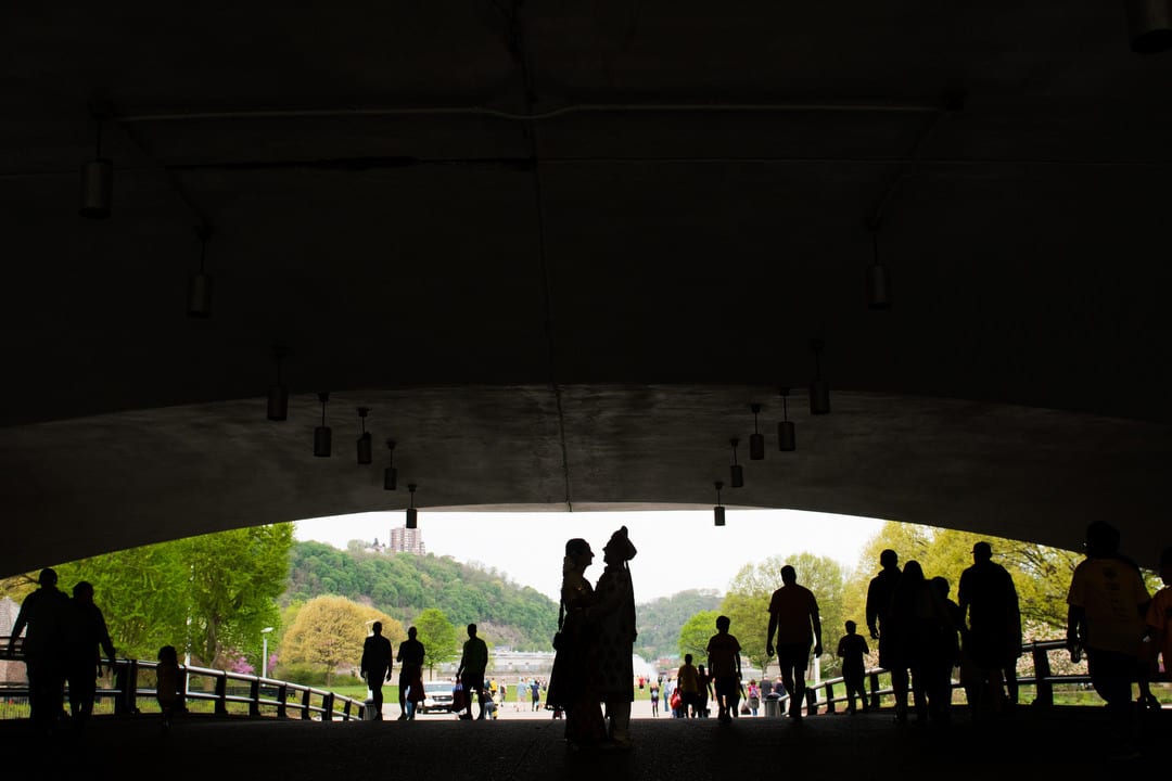 Silhouette of a couple standing beneath the bridge over Point State Park.