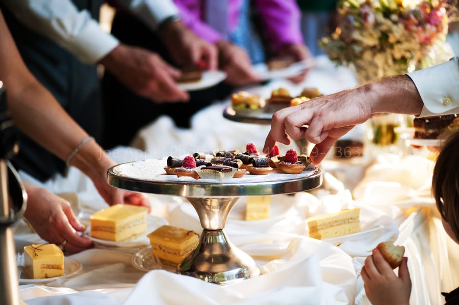 guests at a wedding grab french pastries from a serving dish