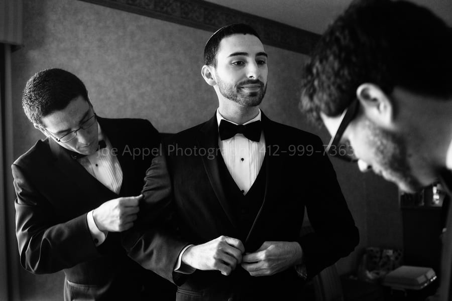 groomsmen help a groom get his jacket on West Virginia Wedding Photography