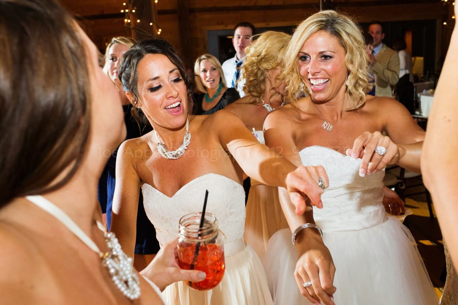 bride and her bridesmaids dance in a group