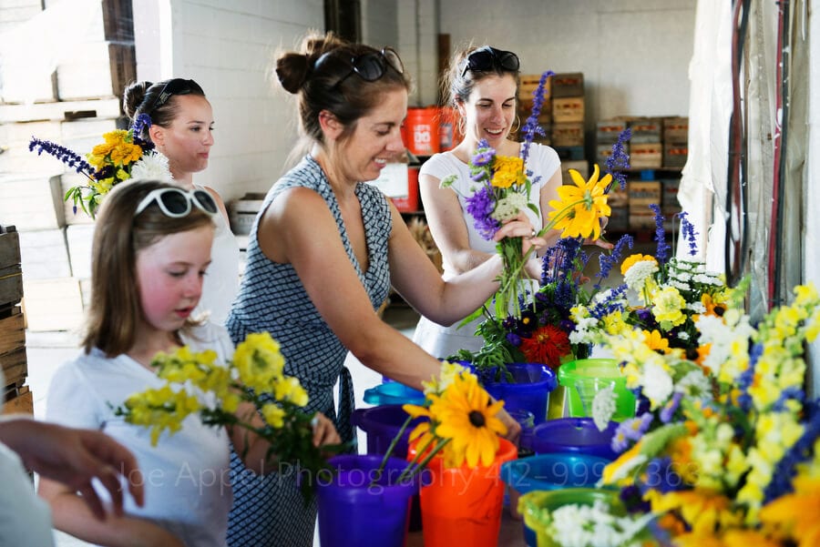 women and girls put together arrangements from fresh cut flowers outdoor wedding in pittsburgh