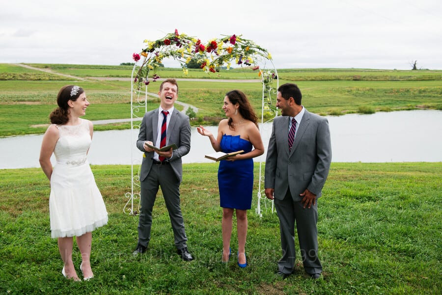 the bride's brother laughs as he and the groom's sister officiate their respective sibling's wedding outdoor wedding in pittsburgh