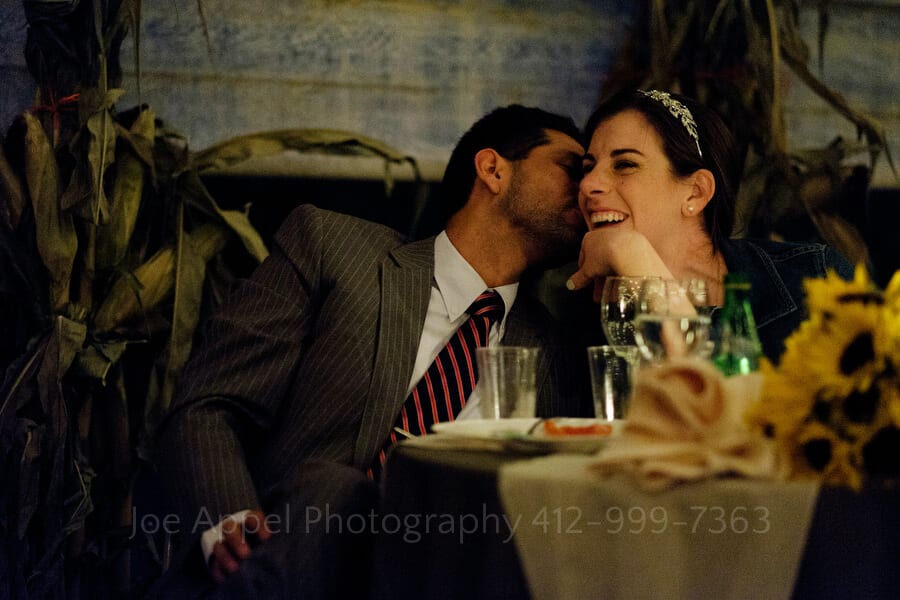 bride laughs while listening to her father's toast and the groom kisses her on her cheek outdoor wedding in pittsburgh