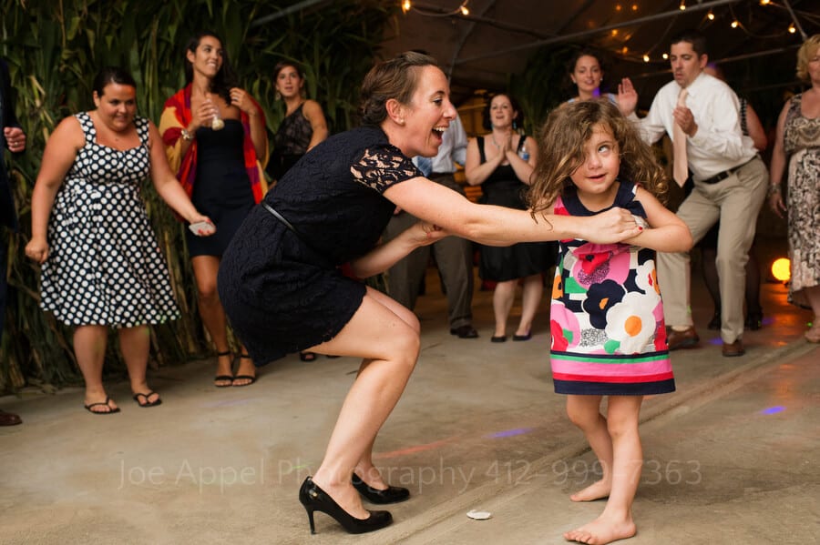 a woman dances with a little girl who makes a funny face outdoor wedding in pittsburgh