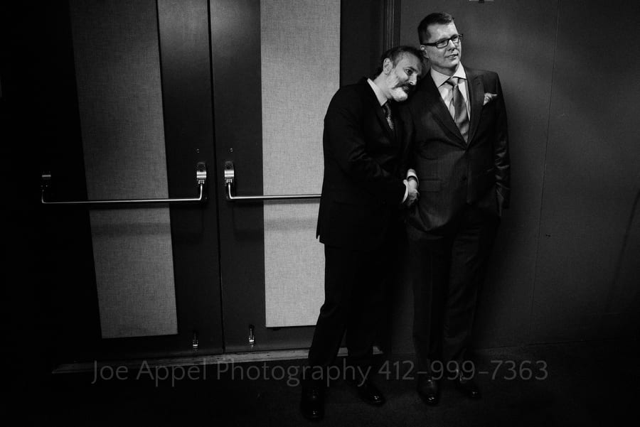 two grooms stand close together before saying their wedding vows andy warhol museum wedding