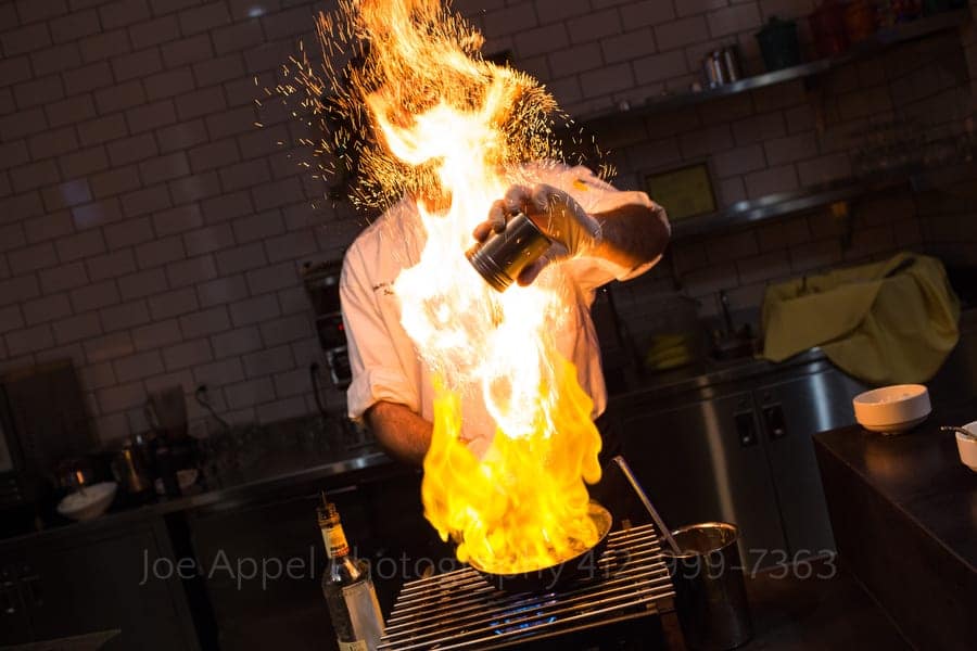 flames shoot up in front of a chef as he makes bananas foster andy warhol museum wedding