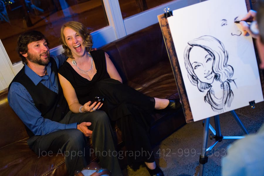 A woman laughs as a caricature artist makes a drawing of she and her boyfriend andy warhol museum wedding