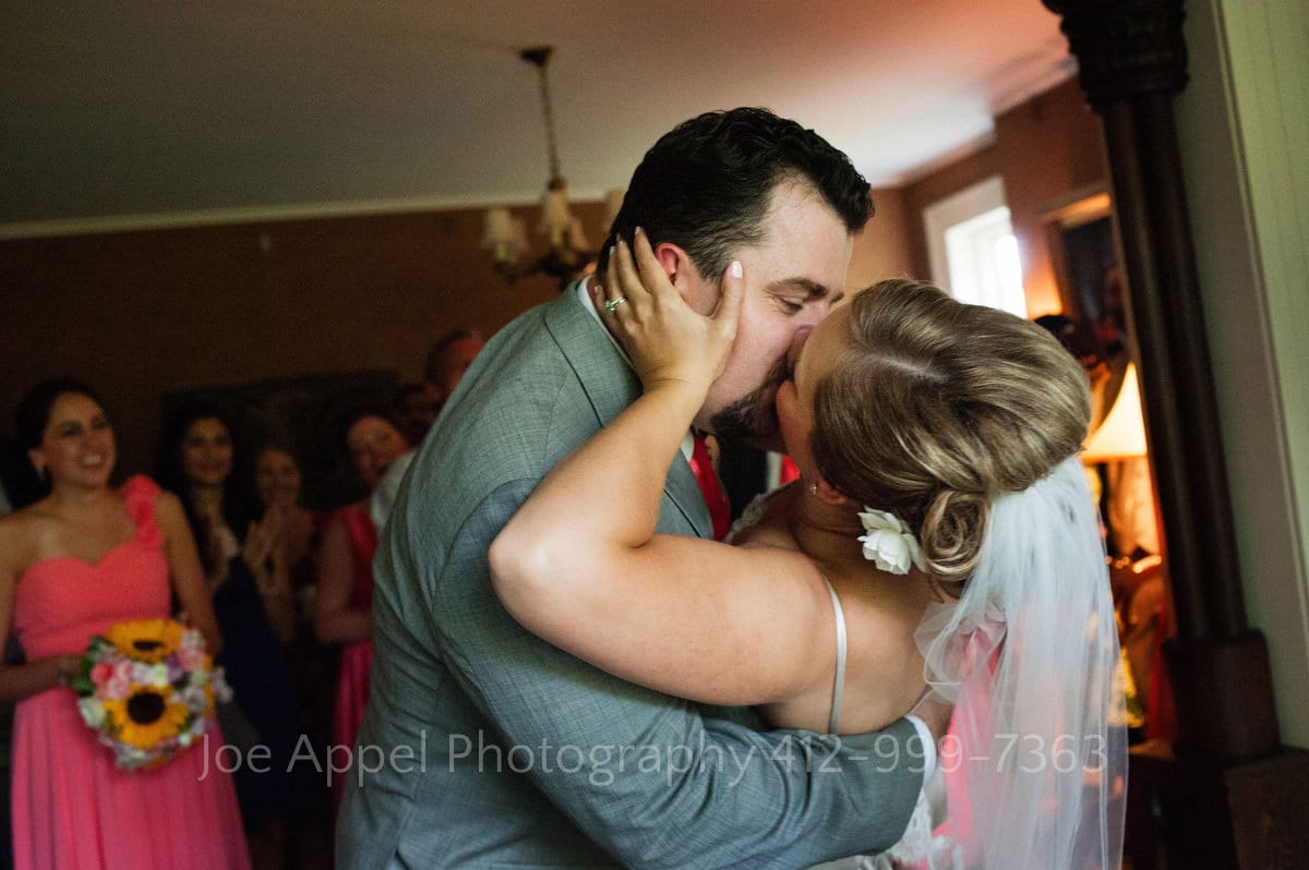 A bride and groom kiss after cutting the cake at their Succop Conservancy wedding