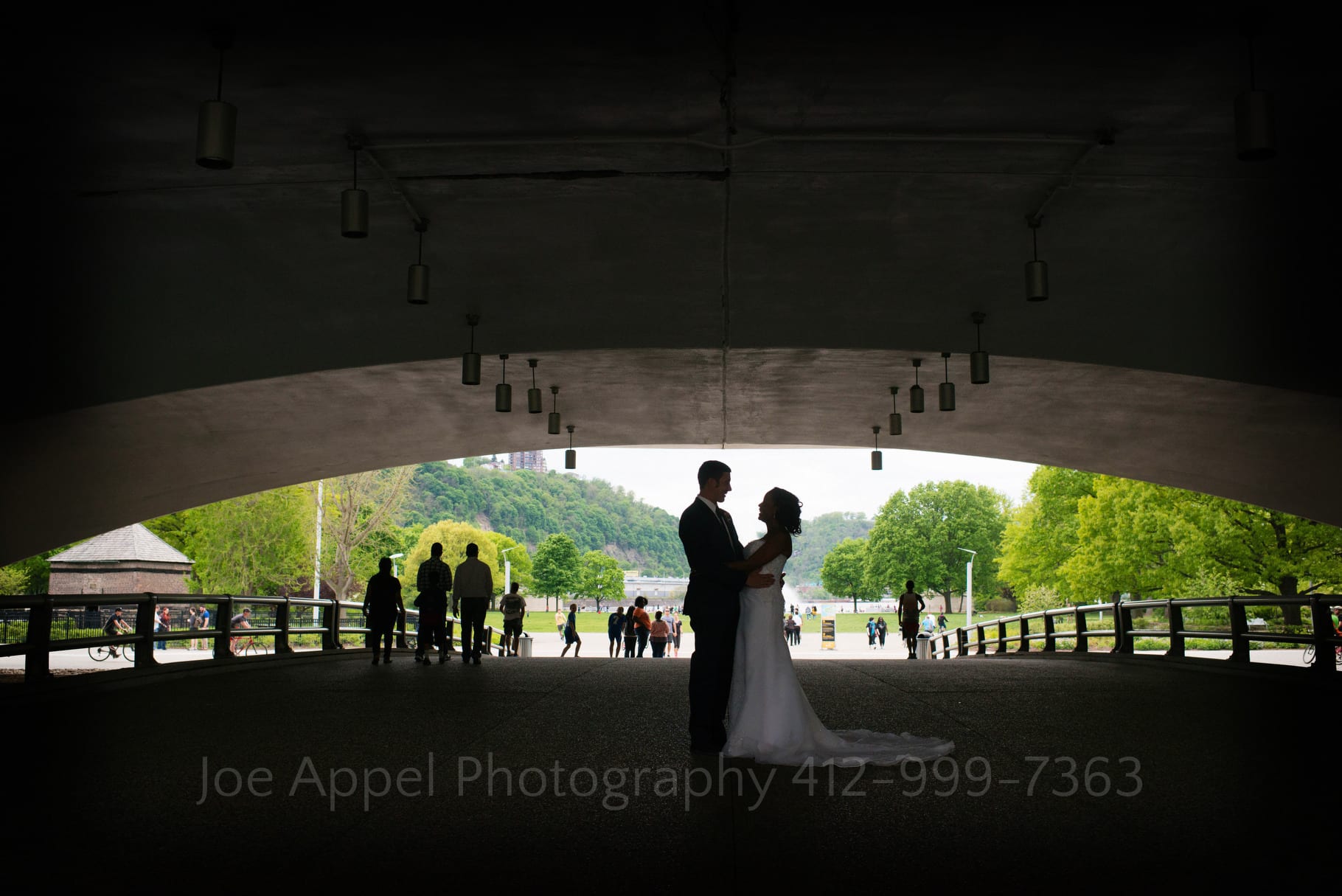 Bride and groom are silhouetted on the walkway leading to Point State Park in Pittsburgh.