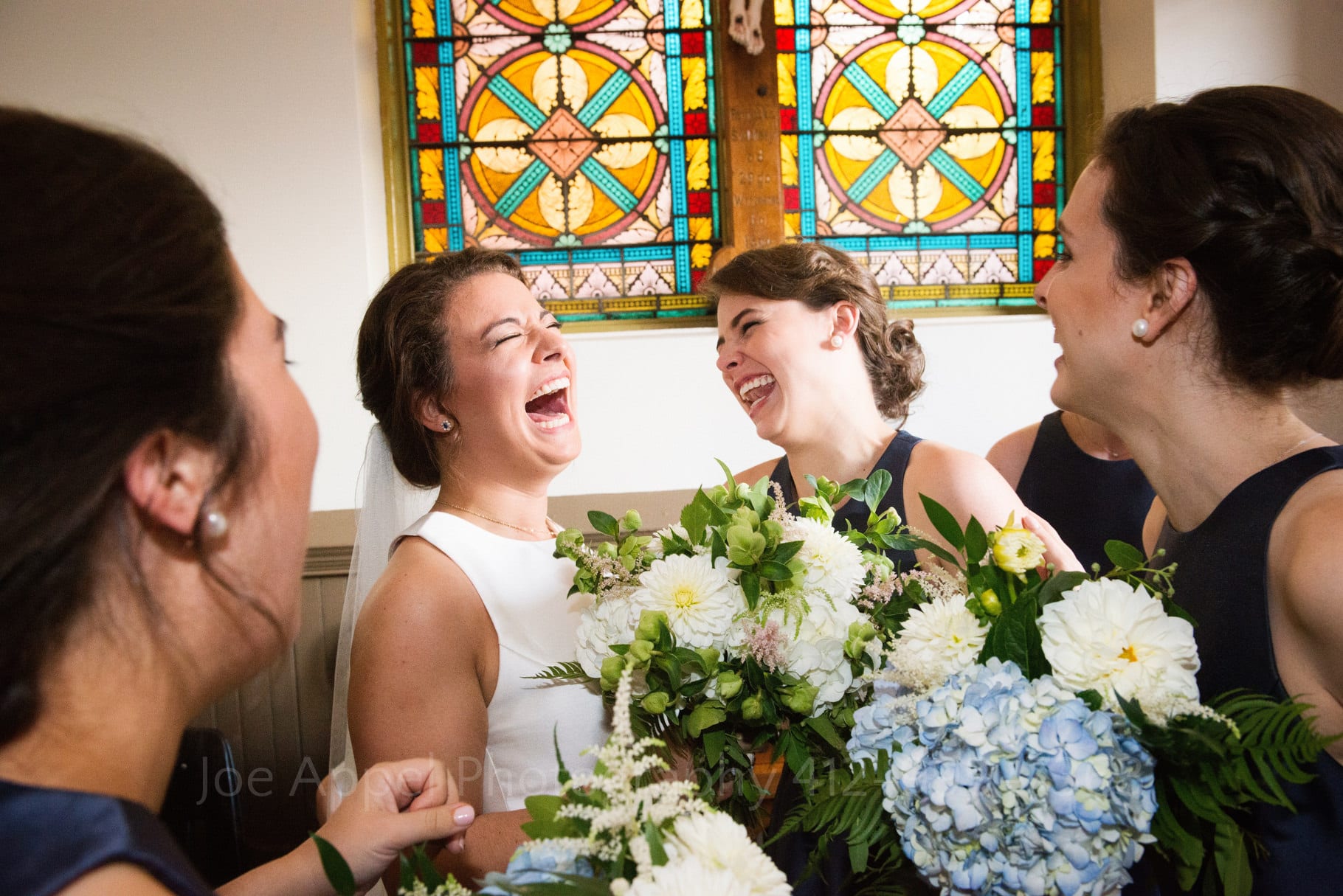 A bride and her bridesmaids laugh with joy after her wedding at St. Stanislaus church in the Strip District.