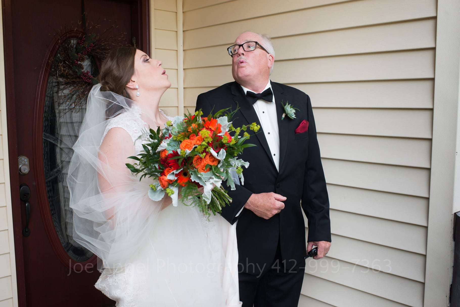 A bride and her father link arms and take deep breaths as they look at each other