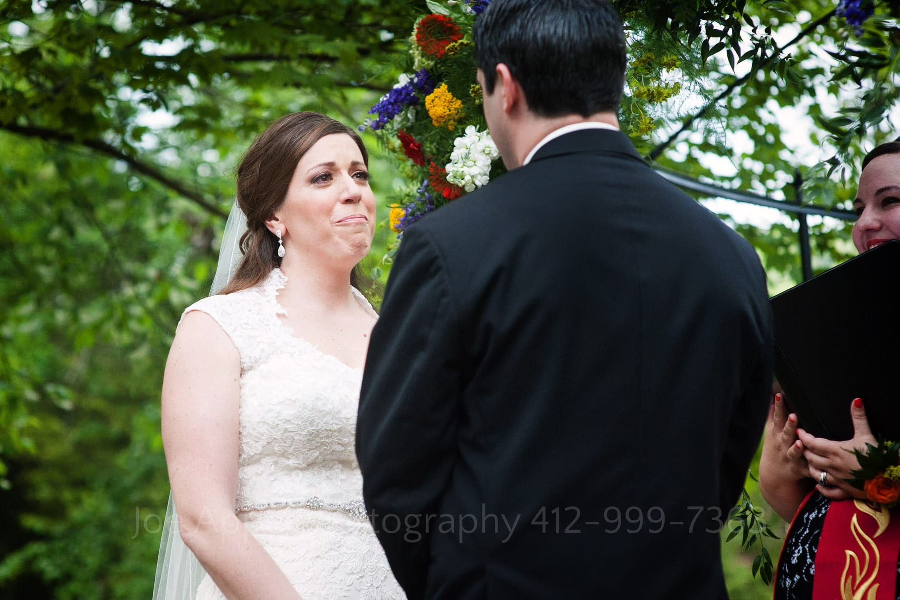 a bride tears up as she says her vows while facing her groom  during their Chanteclaire Farm Wedding.
