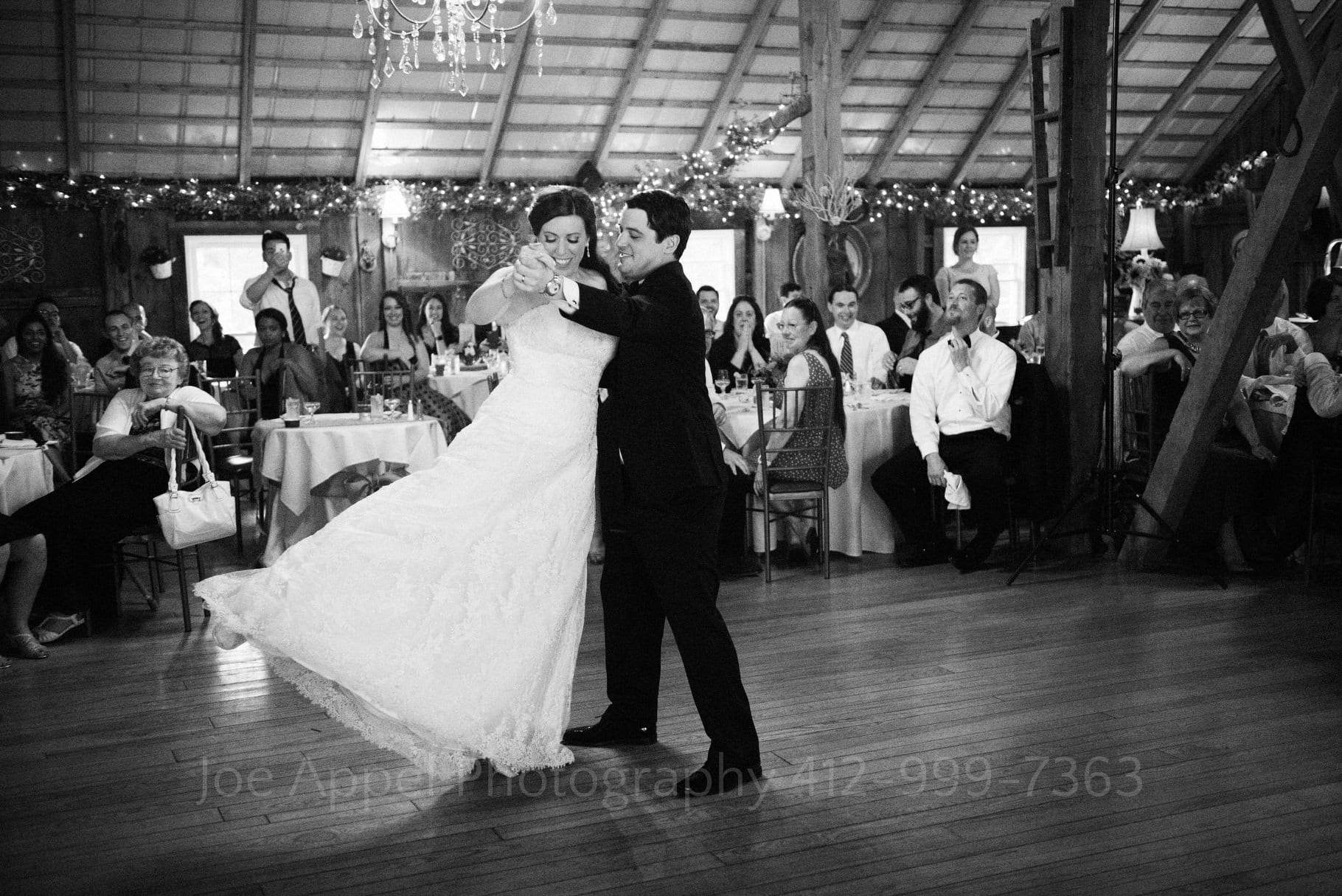 bride swings her leg as she dances with her groom