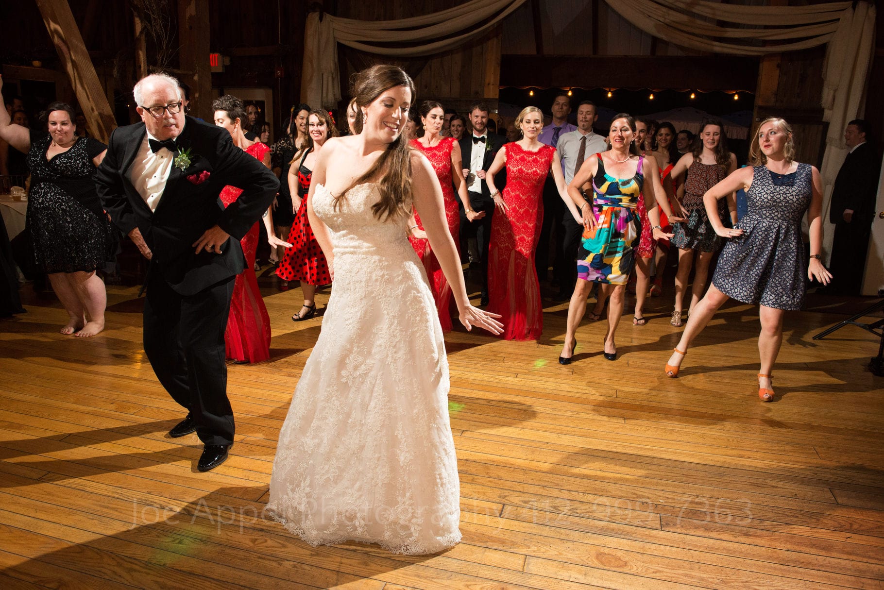 bride and her father dance in front of a crowd of guests as they lead them in a choreographed dance during their Chanteclaire Farm Wedding.