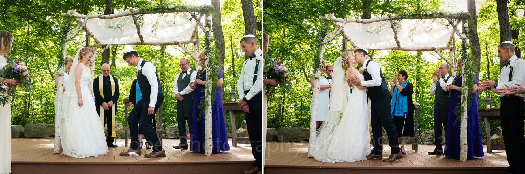 A groom stomps on a glass and then kisses his bride as they stand beneath a chuppah during their Seven Springs Wedding.