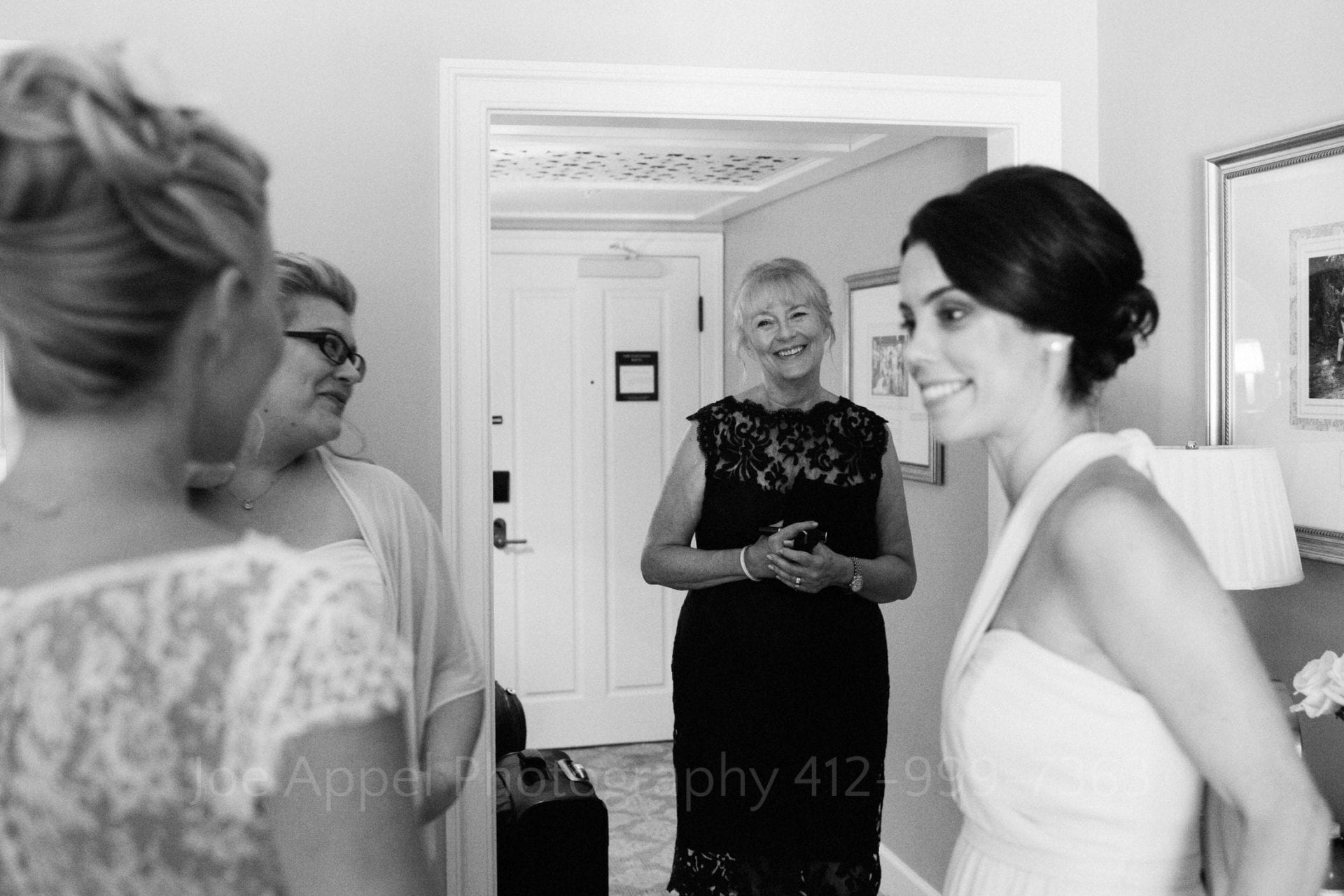 A bride's mother smiles as she enters the room to see her daughter standing in her wedding gown during their Omni Bedford Springs Resort Wedding.