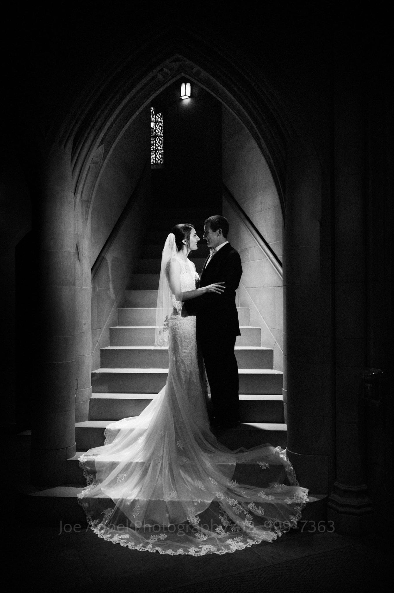 a bride and groom face each other in the archway leading to the choir loft at heinz memorial chapel