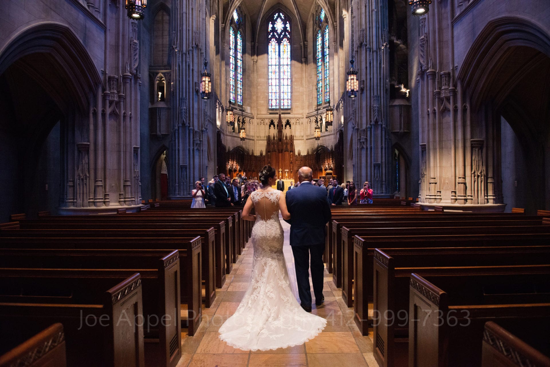 The interior of Heinz Chapel as seen from the back of the church as a bride and her father walk down the aisle at her Heinz Chapel and LeMont Wedding.