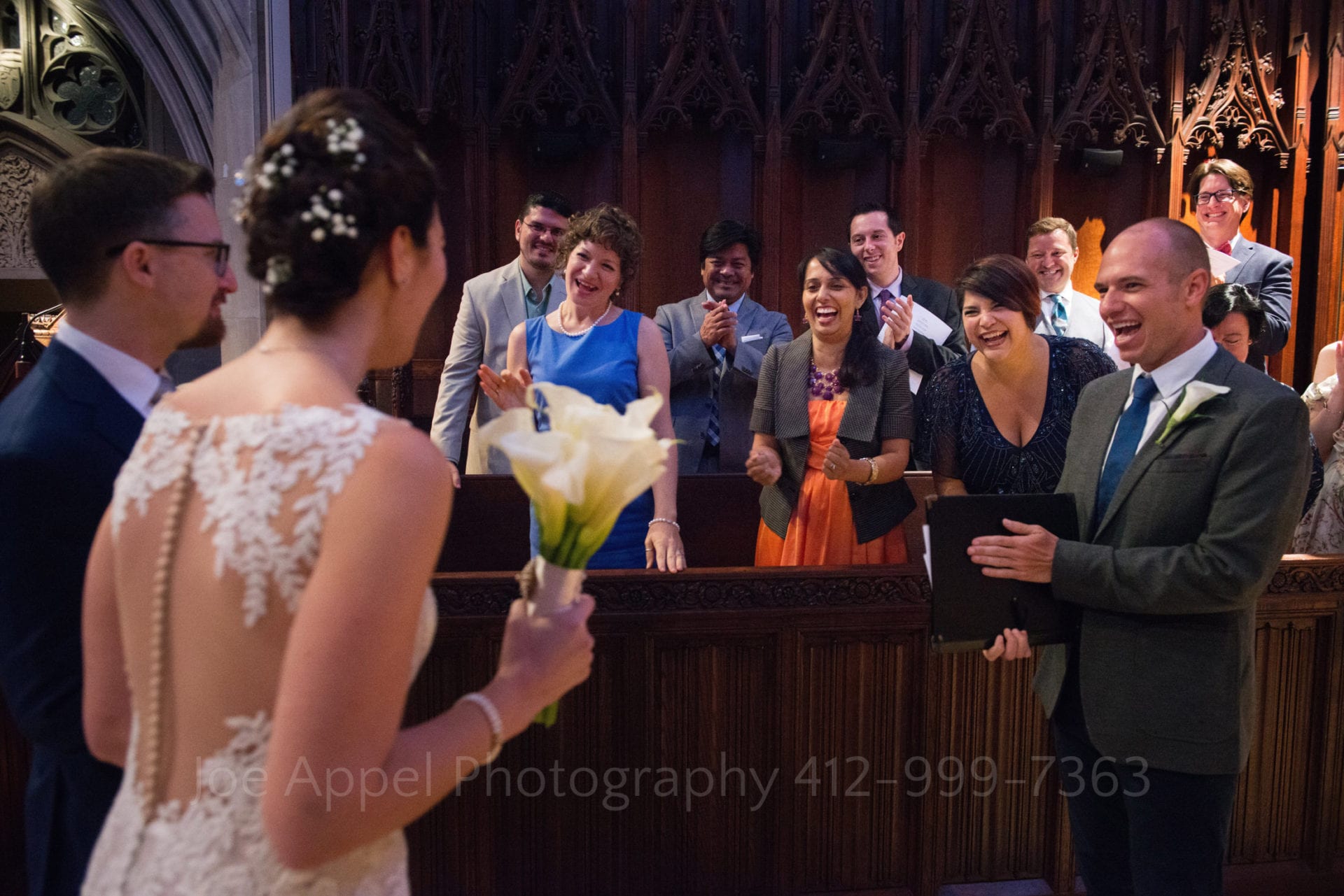 A choir smiles as the bride and groom approach them from the left during their Heinz Chapel and LeMont Wedding.