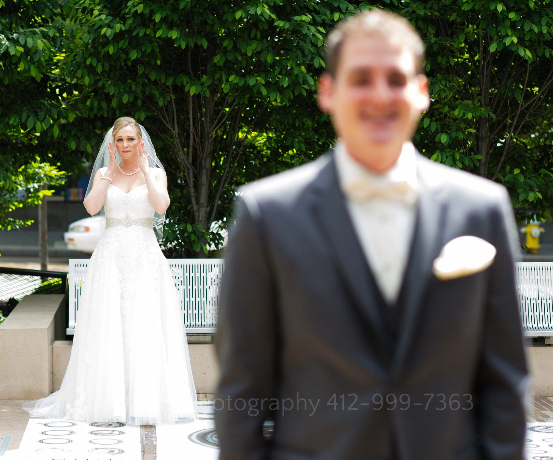 A bride wipes tears from her eyes before walking up to her fiance who stands facing away from her Fairmont Hotel Pittsburgh Weddings.