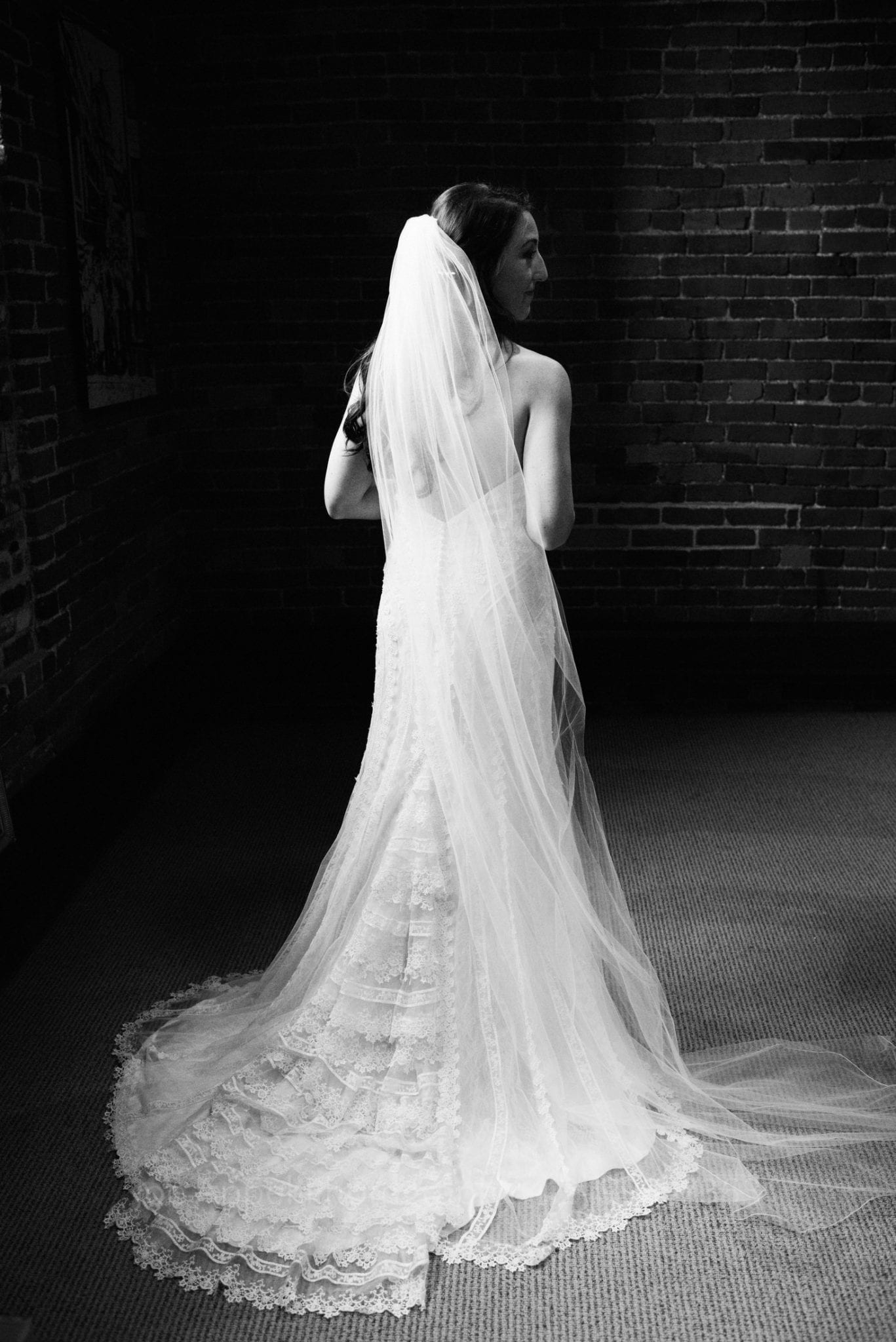 Bride seen from behind with long veil and train in the library & archives conference room